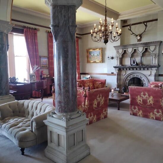 Common area with sofas and fireplace in Camelot Castle