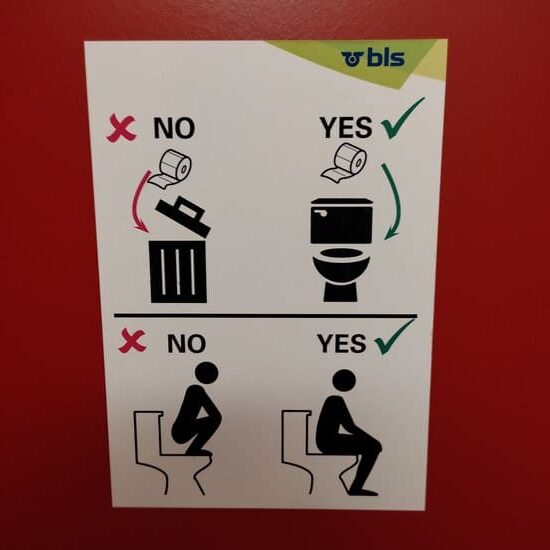 Sign that shows you are supposed on toilet seat not squat on top of toilet