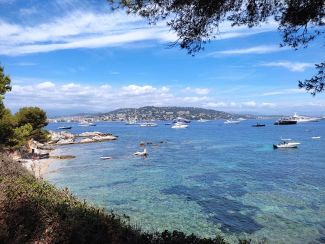 Blue sea with yachts as seen from island with Cannes in the distance