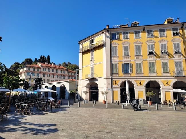 Sunny plaza with cafés and bright yellow building