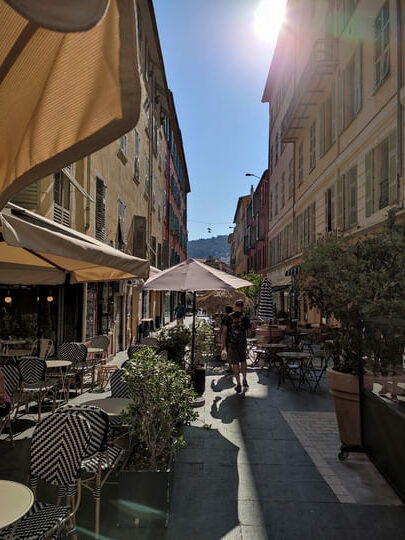 Street with chairs and tables outside in the sunshine