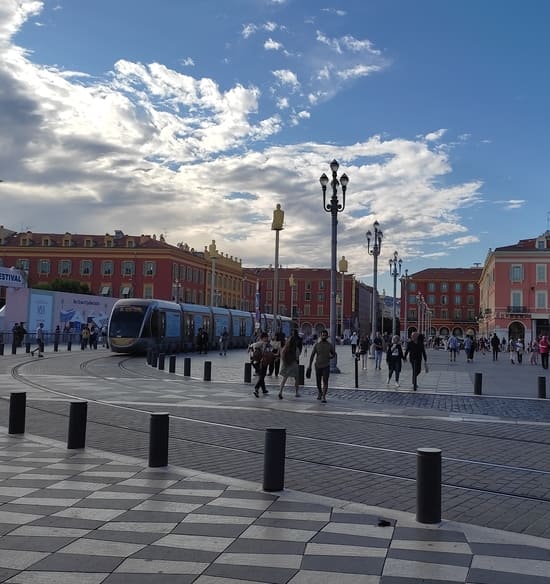 Tram on wide plaza with checkerboard stones on ground