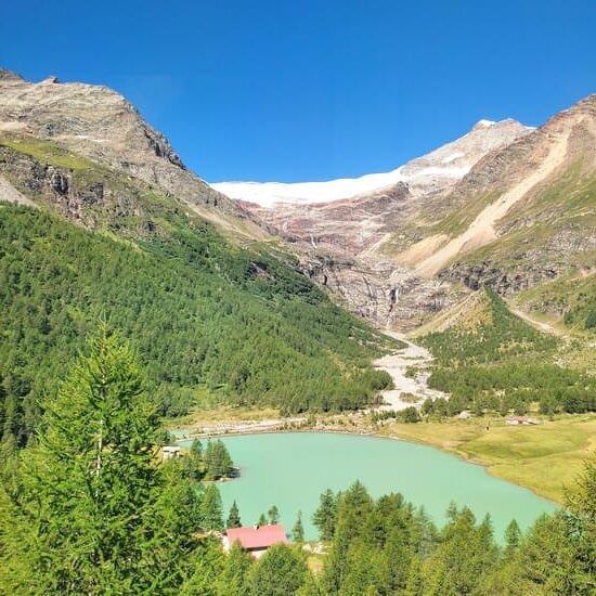 View of mountains with snow on the top and a turquoise lake in the valley