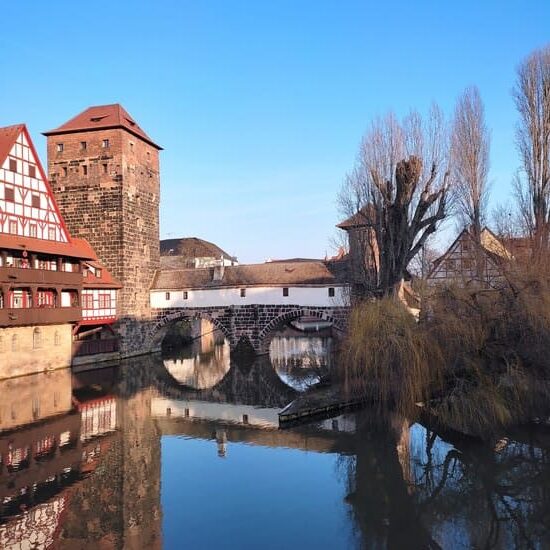 Old bridge in Nuremberg reflected in the river and half-timbered houses next to it