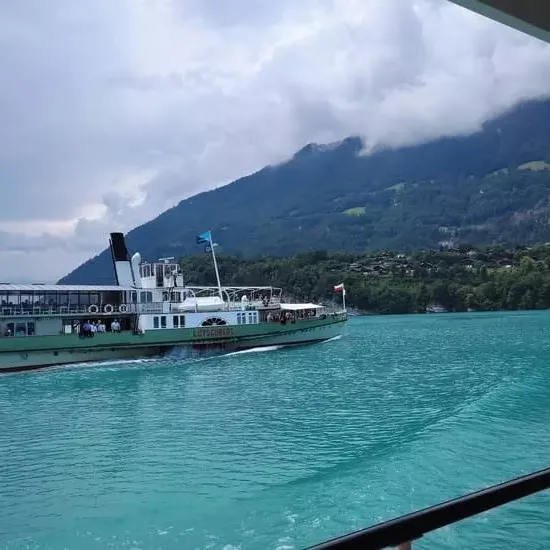 Old-fashioned boat on Lake Brienz under heavy clouds