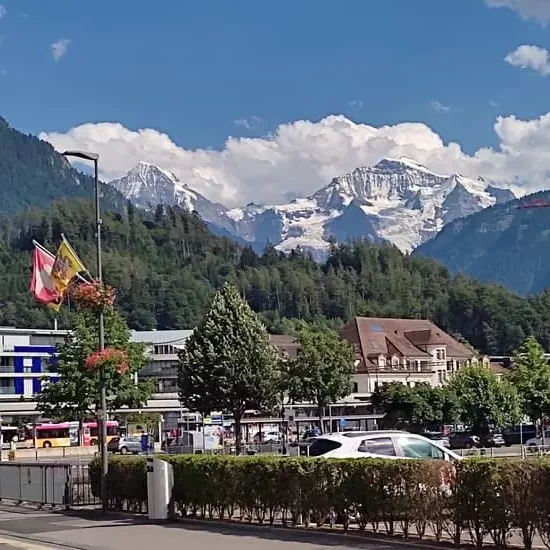 Bright turquoise river Aare in Interlaken with backdrops of wooded mountains