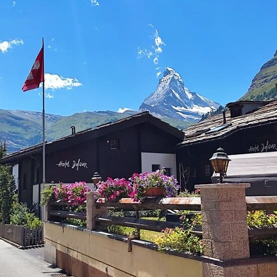 Swiss houses with Swiss flag and Matterhorn in distance