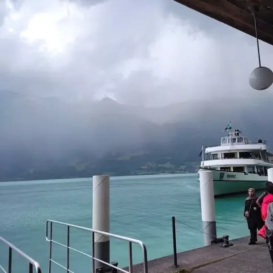 Lake with dark clouds overhead and boat arriving at pier