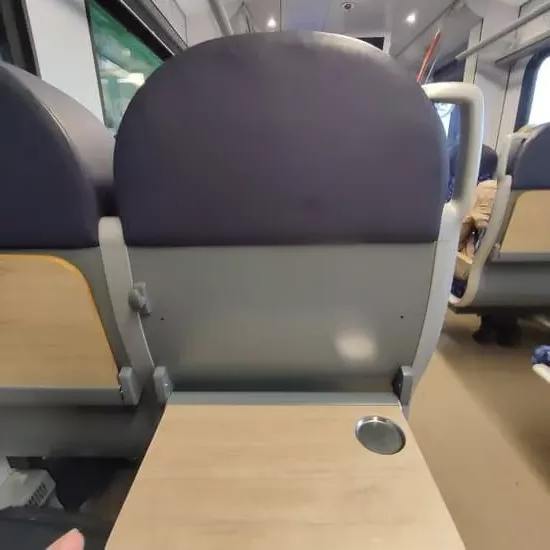 Seat with extended tray in train