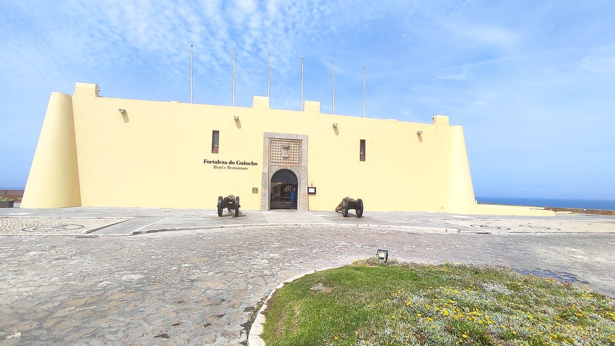 Low rise, pale yellow fortress with canons in front at Guincho