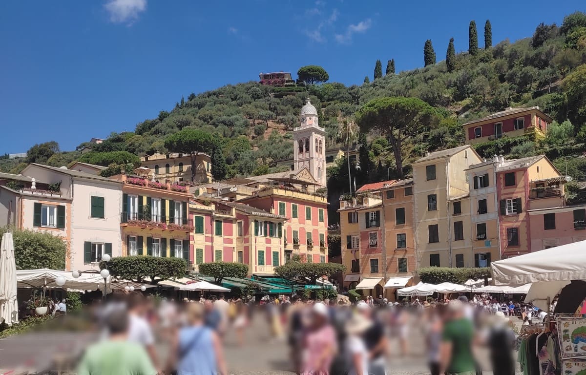 Portofino's main square is crowded with tourists but you can still see the beautiful church and the colorful buildings.