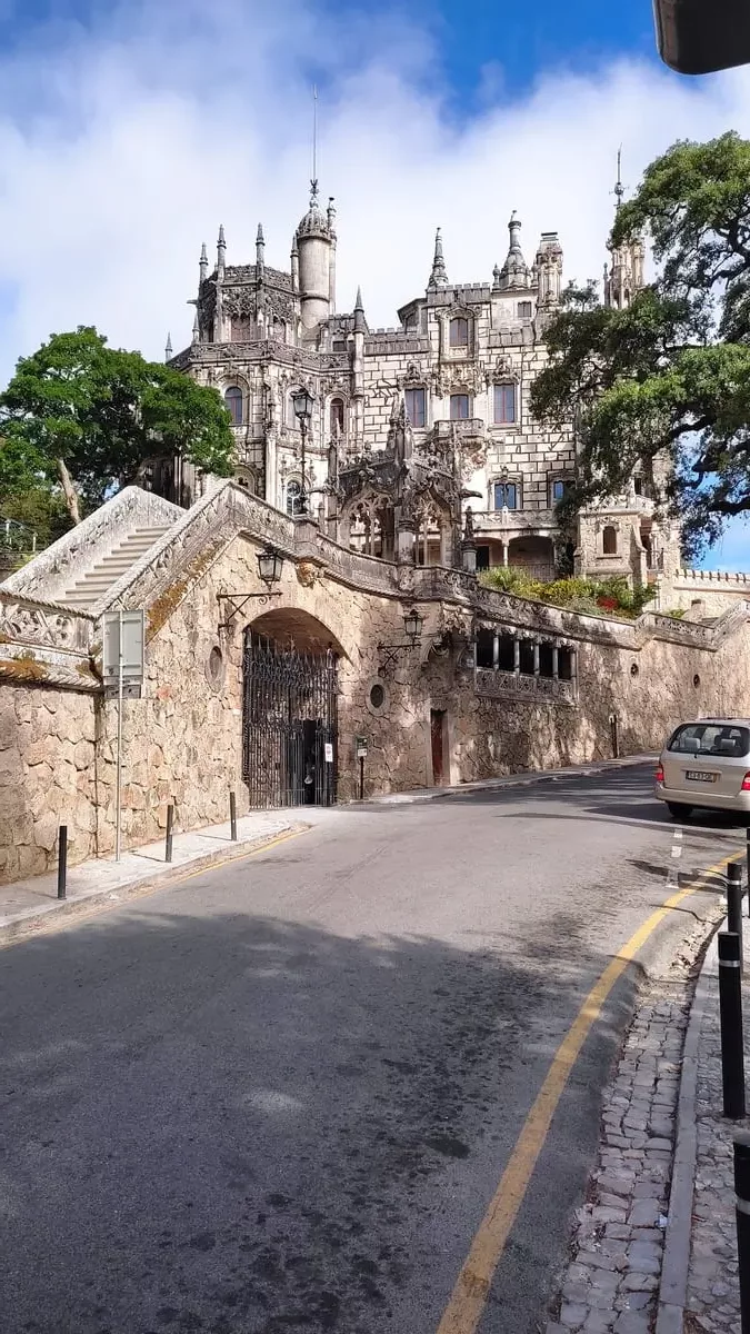 Seen from the street, Quinta da Regaleira with its many turrets, windows, and distinct stonework looks almost unreal. The surrounding wall with a large iron gate adds to the air of mystery of this Sintra attraction.