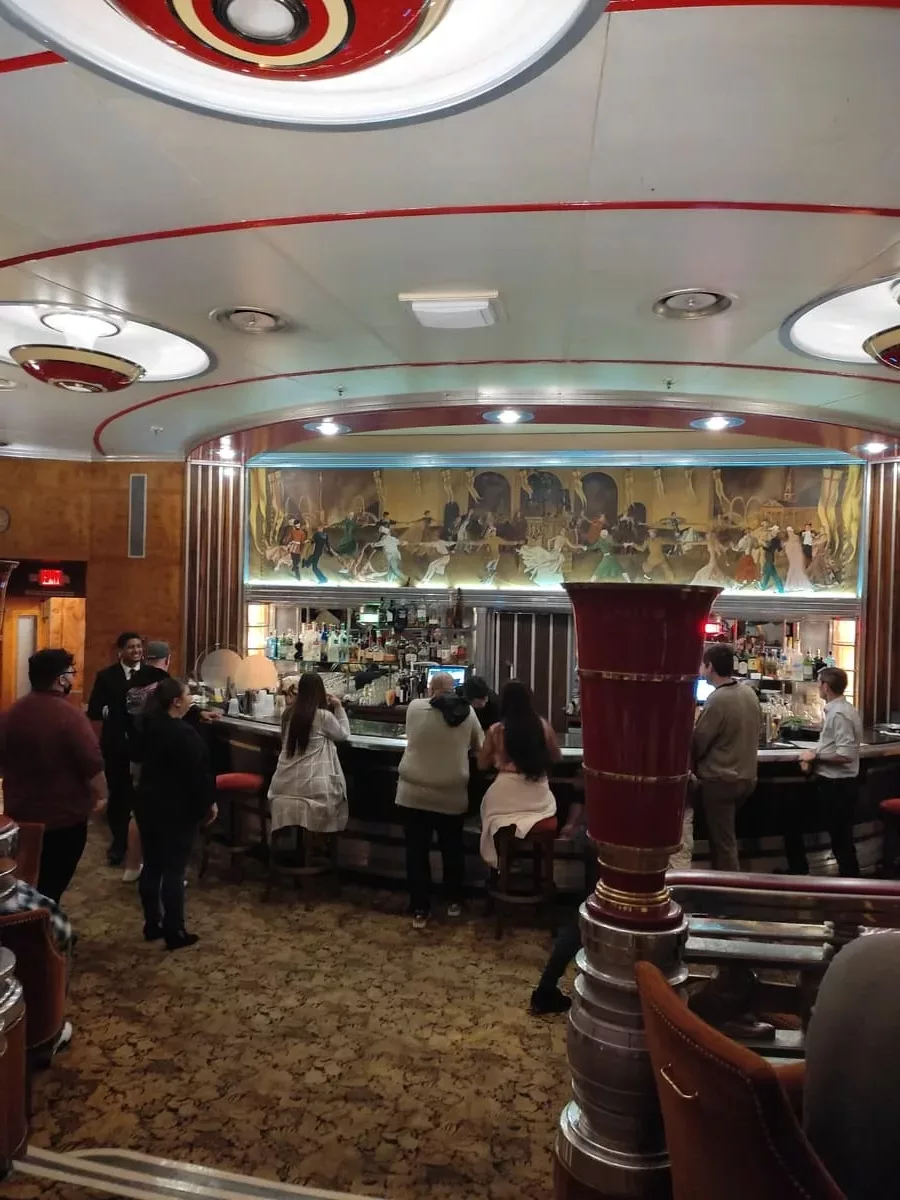 The Paranormal Walk Tour takes a break in the Observation Bar. Above the bar is a beautiful mural and unique red, black, yellow lamps are on the ceiling.