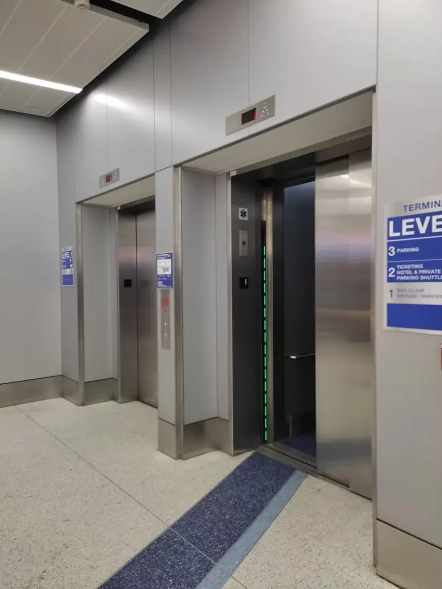 Two large metal doors to elevators on Level 1 at LAX terminal 7. Departures are up on level 2 at Los Angeles International.