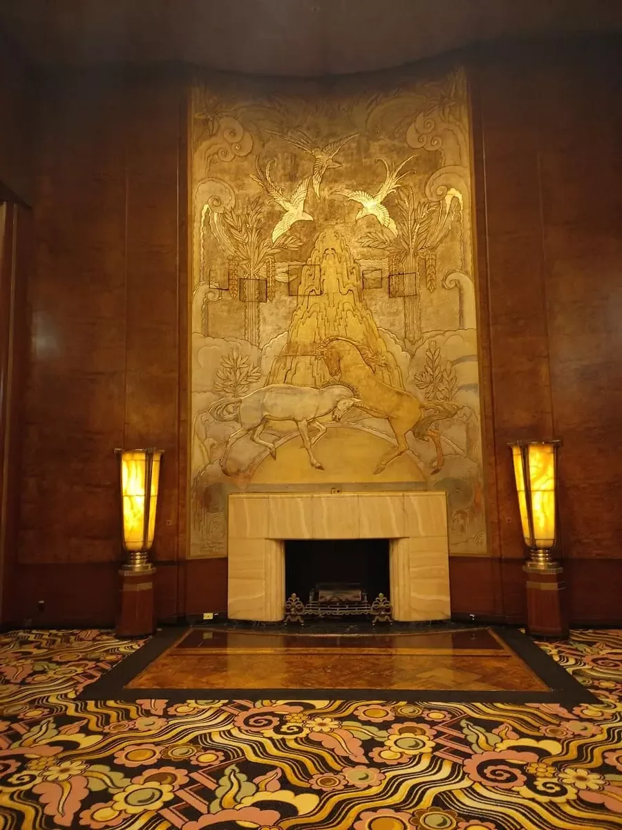 The large fireplace with its golden mural of two fighting unicorns is the most important feature of the Queens Room. However, the vividly colored carpet with large flowers evokes the 1970s.