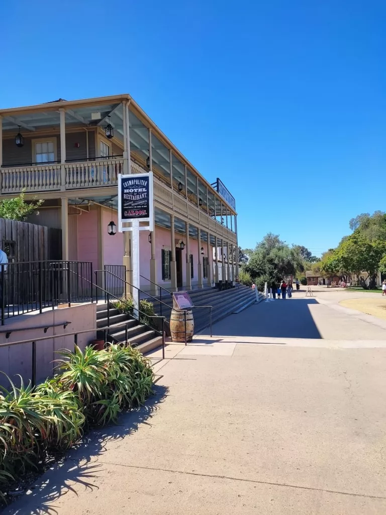 The pink and white balustrated building houses the Hotel Cosmopolitan right in Old Town San Diego. It looks like it is straight out of a Western.