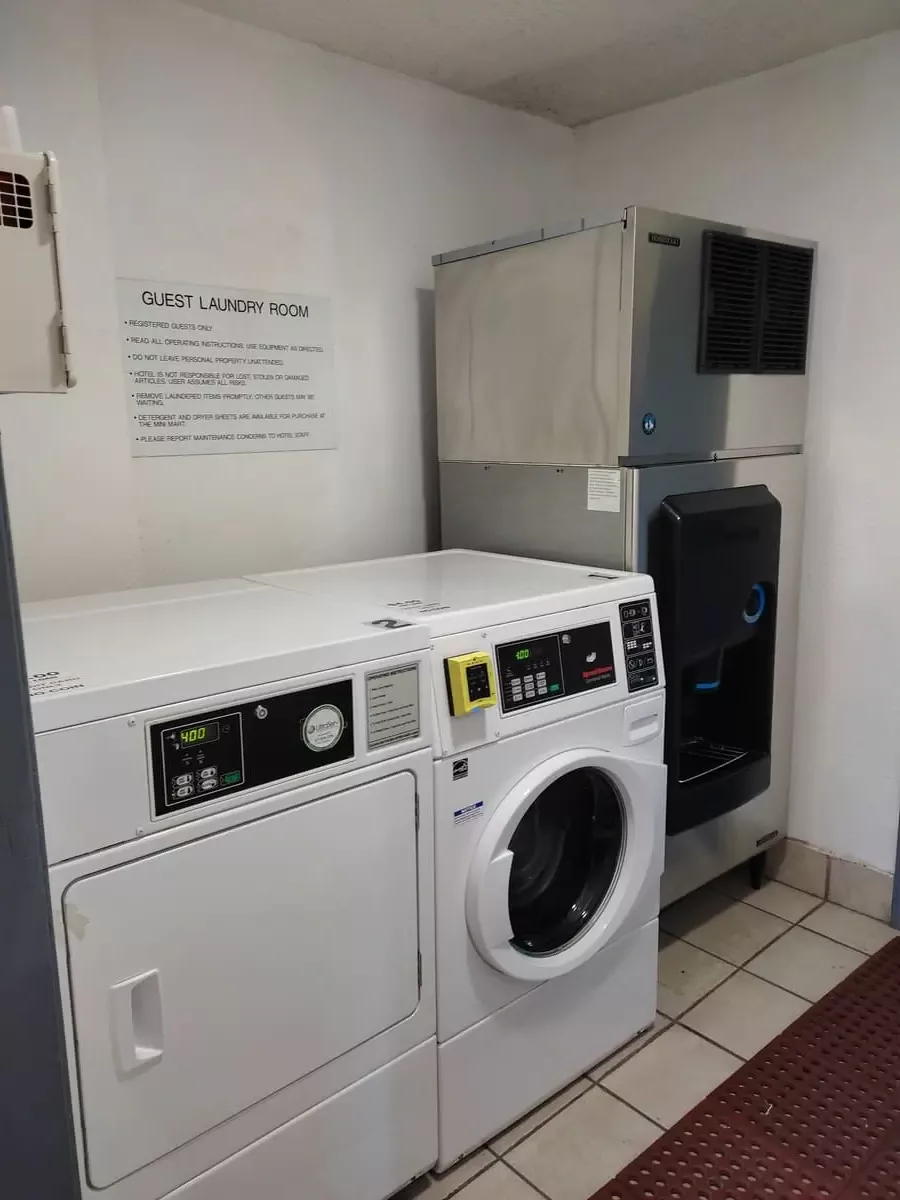 Ice machine, washing machine, and dryer in small tiled room at Capri Suites Anaheim