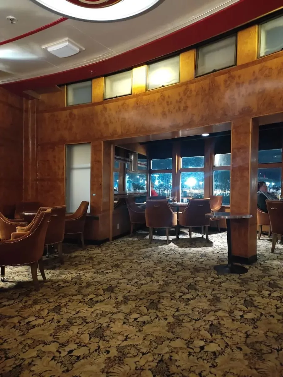 View of Queen Mary's beautiful Observation Bar in the Art Deco Style. From the cozy seats you have a beautiful view of Long Beach at night.