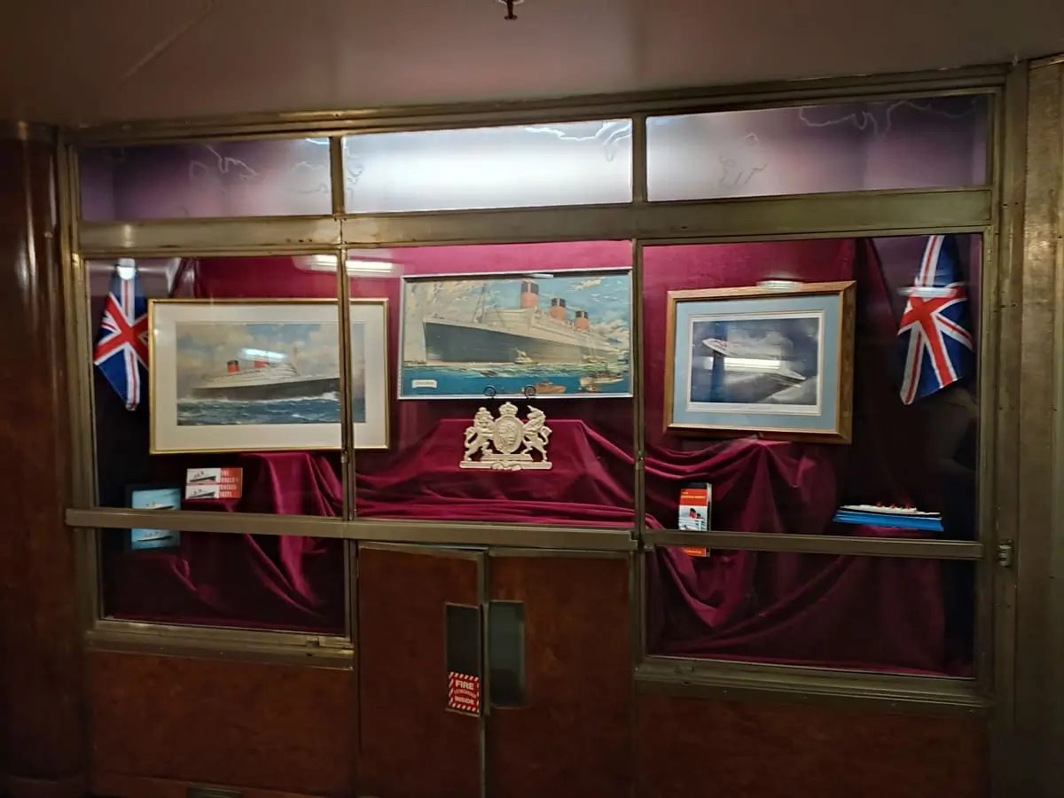 Large cabinet on Queen Mary with purple velvet showing Union Jack flags and paintings of Cunard's Queen Mary