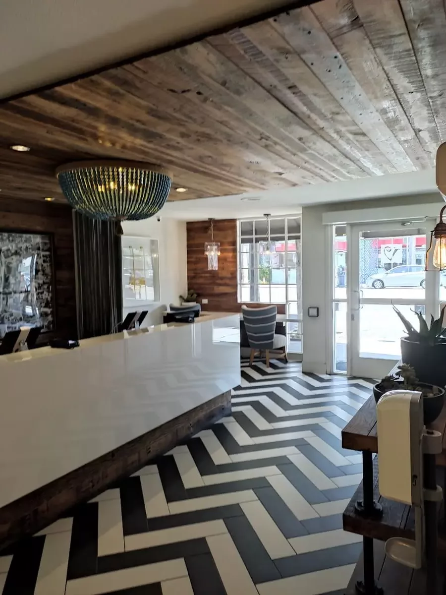 Airy lobby of Inn at Venice Beach with black and white floor and wooden ceiling