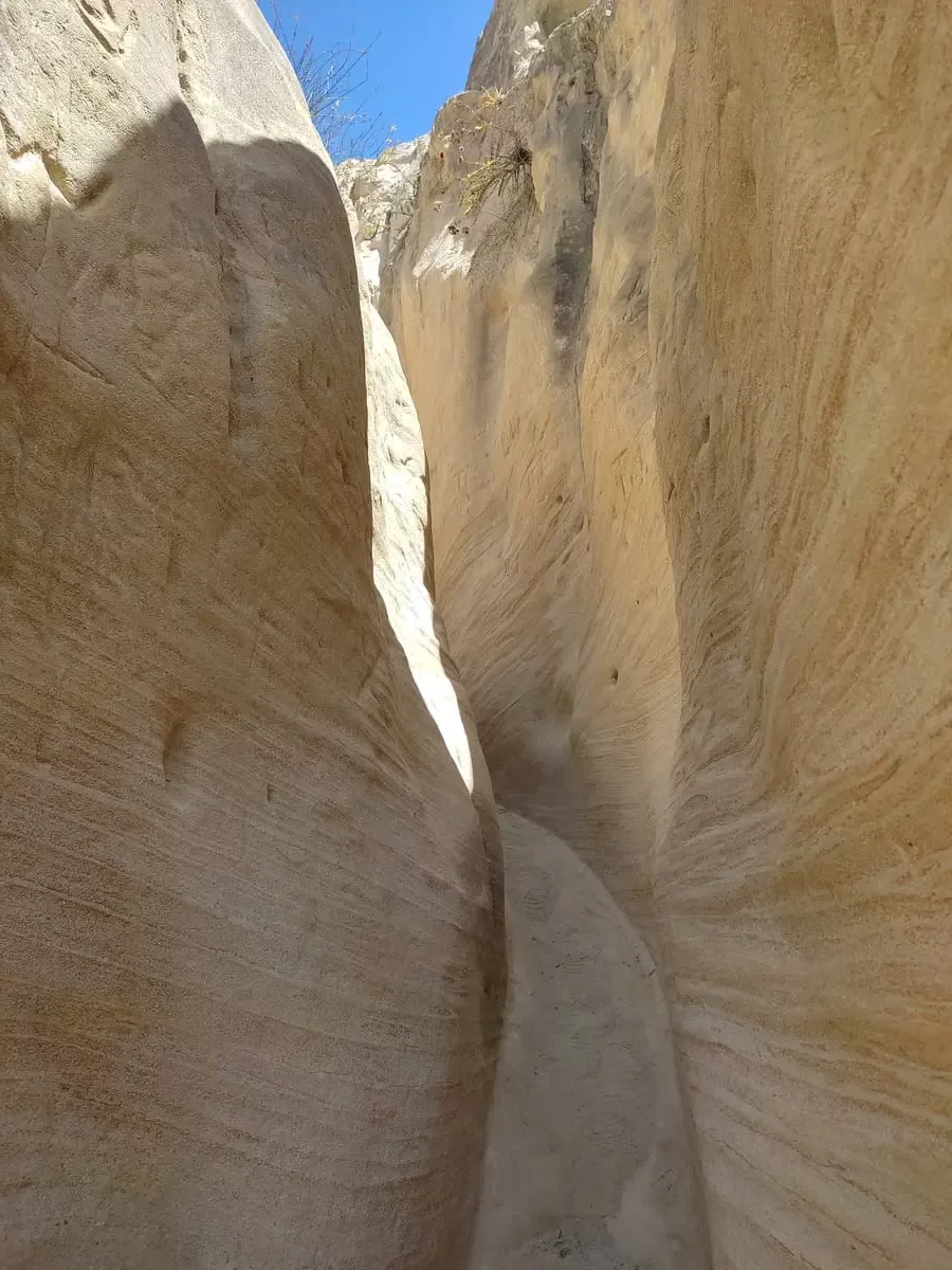 The slightly muddy path between the walls of the slot canyon isvry narrow