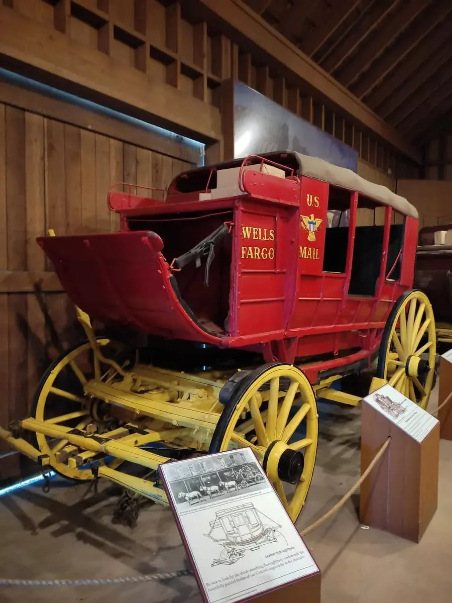 Old-fashioned red and yellow Wells Fargo Mail coach in the old stable building