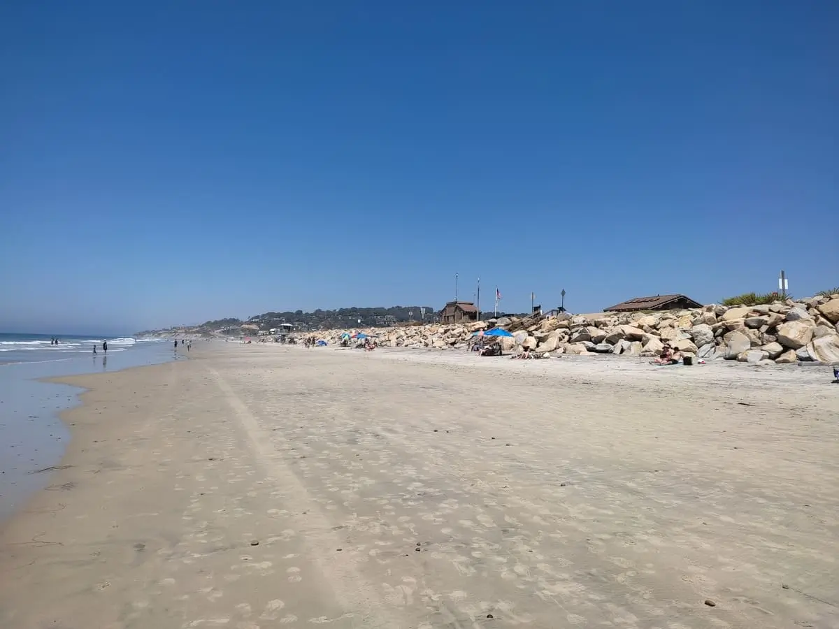 Wide sand beach at Torrey Pines with people on sand. Surprisingly few people are in the water