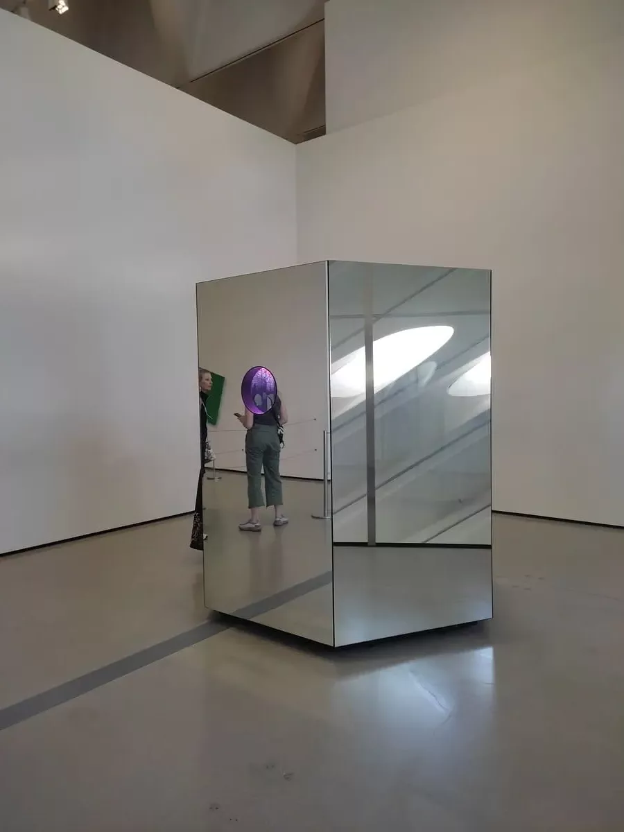 The second of Kusama's Mirrored Rooms at the Broad is a large box with mirrored outside and three portholes in different heights from which to admire the kaleidoscope inside