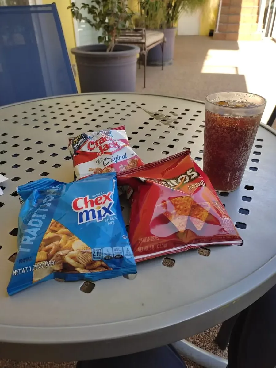 Small round table with three different small treat bags and a glass with Coke