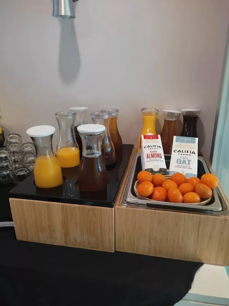 Juice in glass bottles and various vegan milk alternatives at Continental Breakfast at Magic Castle Hotel