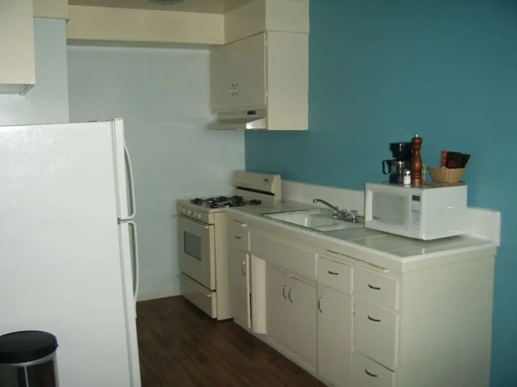 Old fashioned kitchen with turquoise walls and cream cabinets