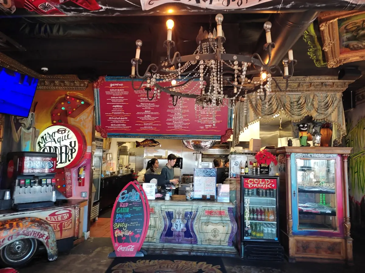 Colorful interior of Sancho's Tacos in San Clemente with menu board overhead