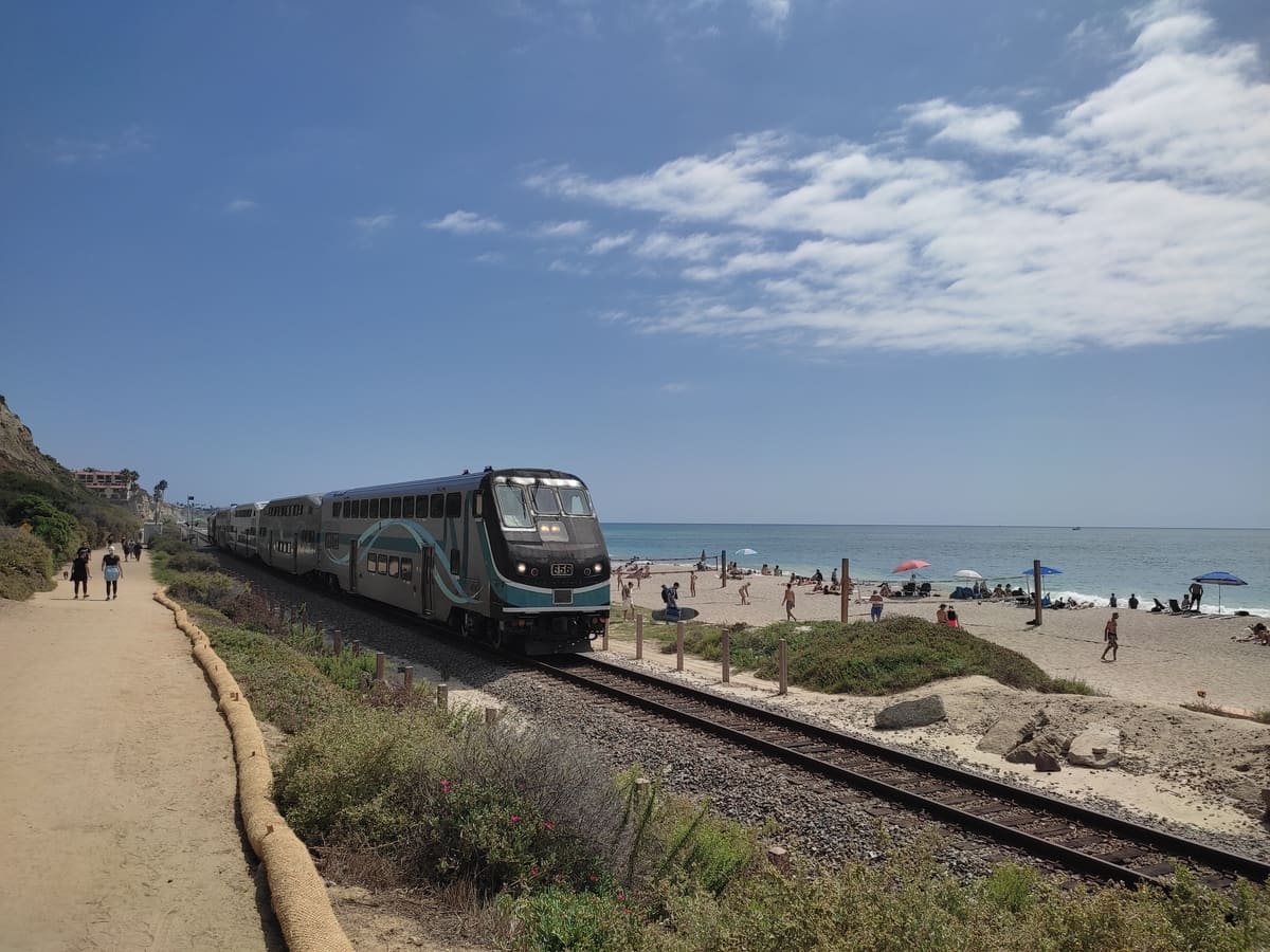 The train tracks separate the sandy beach from the beach trail connecting the pier with San Clemente State Beach