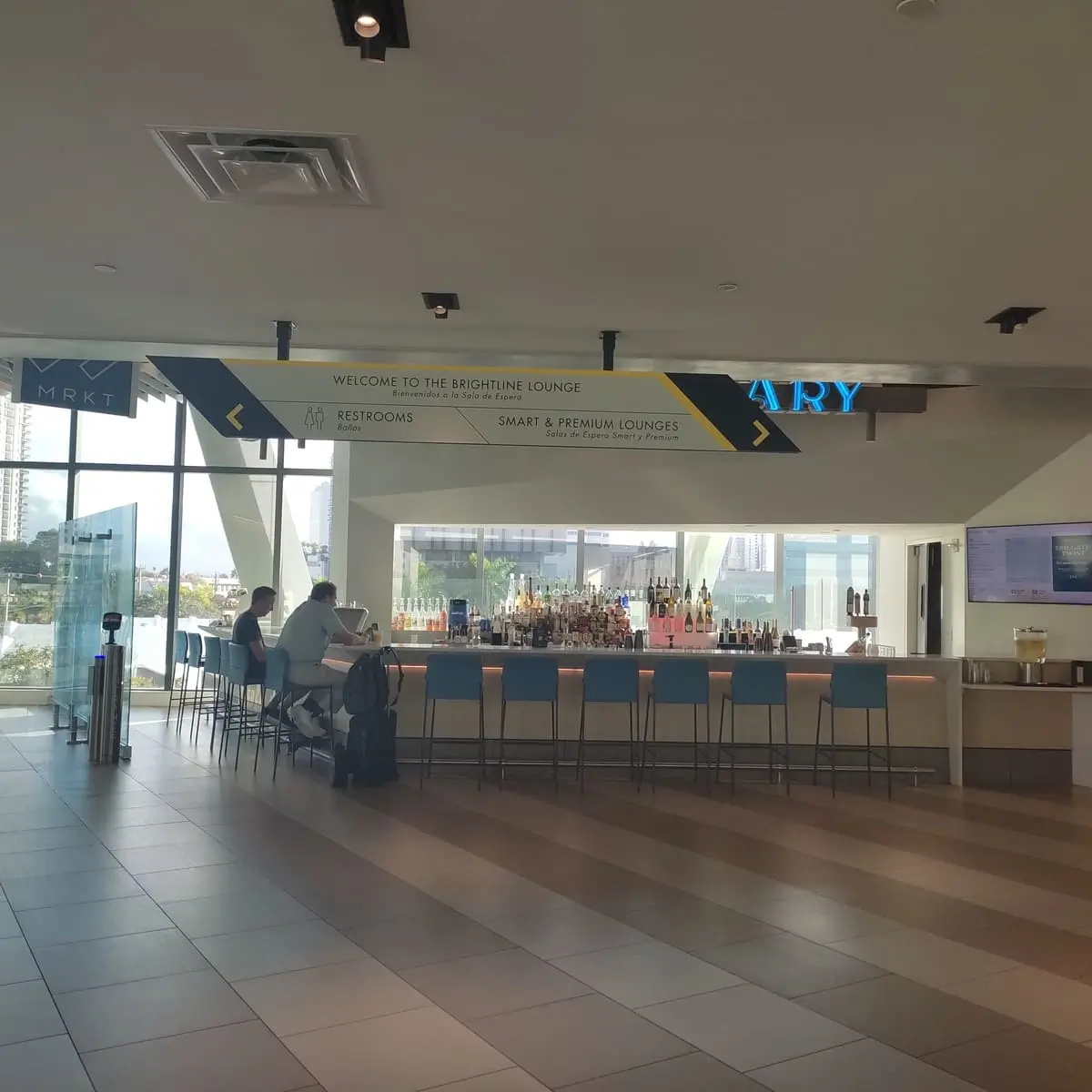 A small bar sells drinks upstairs next to the lounges inside the Brightline station