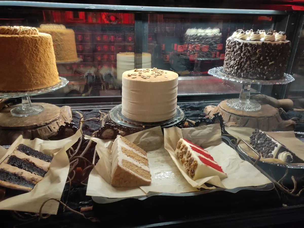 Glass case with cakes and enormous slices cut out