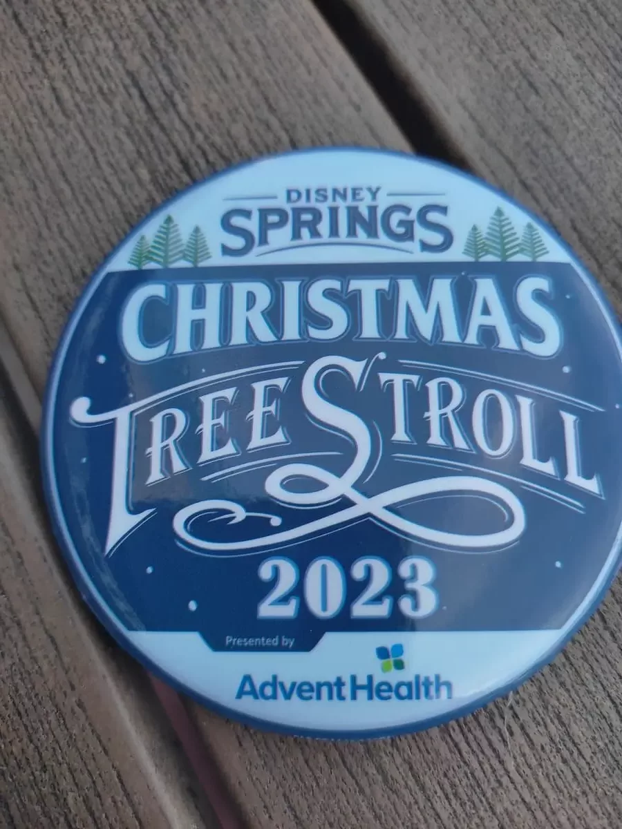 Round badge with Disney Springs Christmas Tree Stroll 2023 written on it