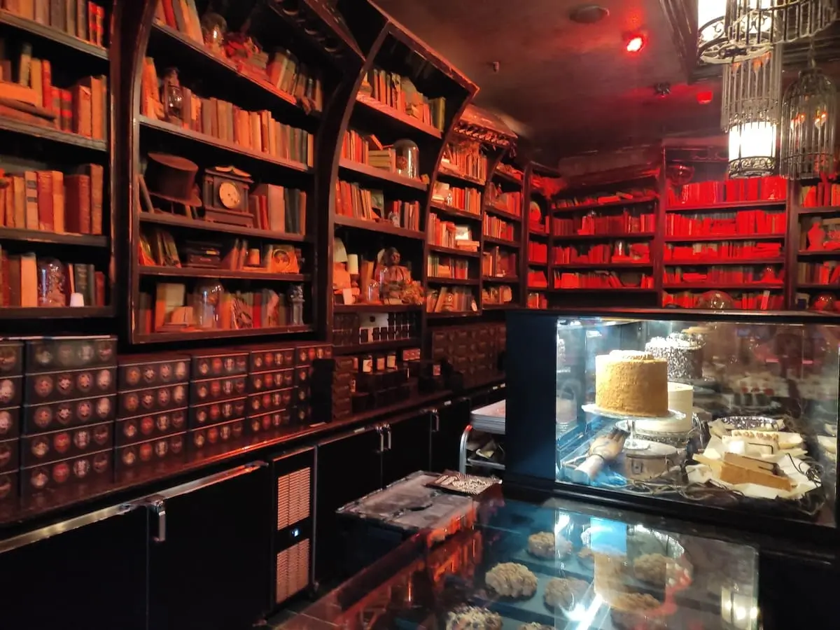 Wooden bookshelves along the wall, gloomy red lighting and ghostly decorations make the inside of Gideon's Bakehouse look like a cross between Hogwarts and the Addams Family.