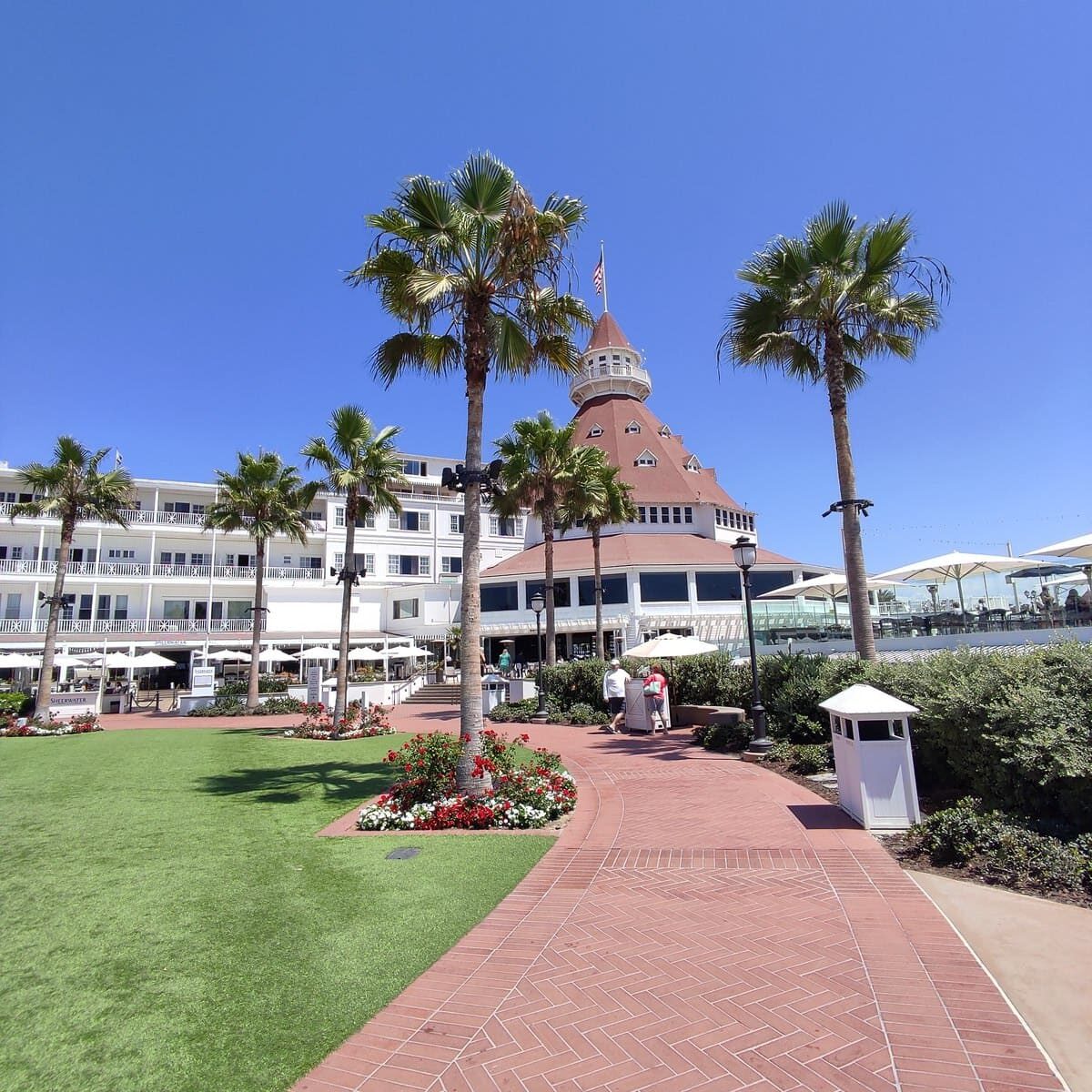 Hotel Del Coronado with white building, red roofs, and manicured gardens
