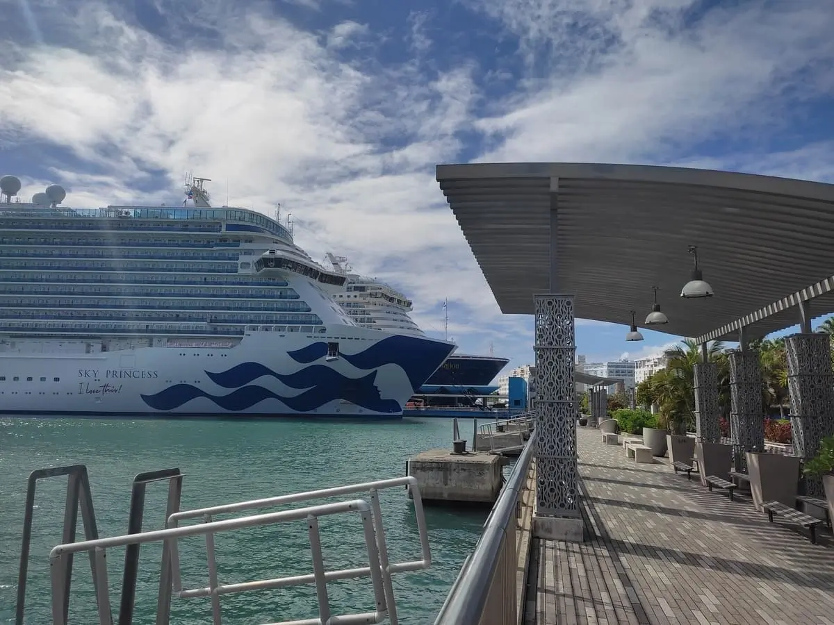 Sky Princess docked in Puerto Rico. Next to ship is a promenade with comfortable benches