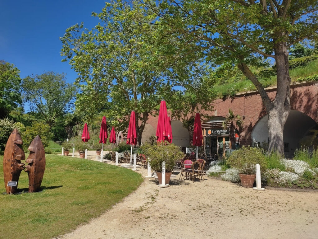 Small cafeteria with seats outside next to statues in park