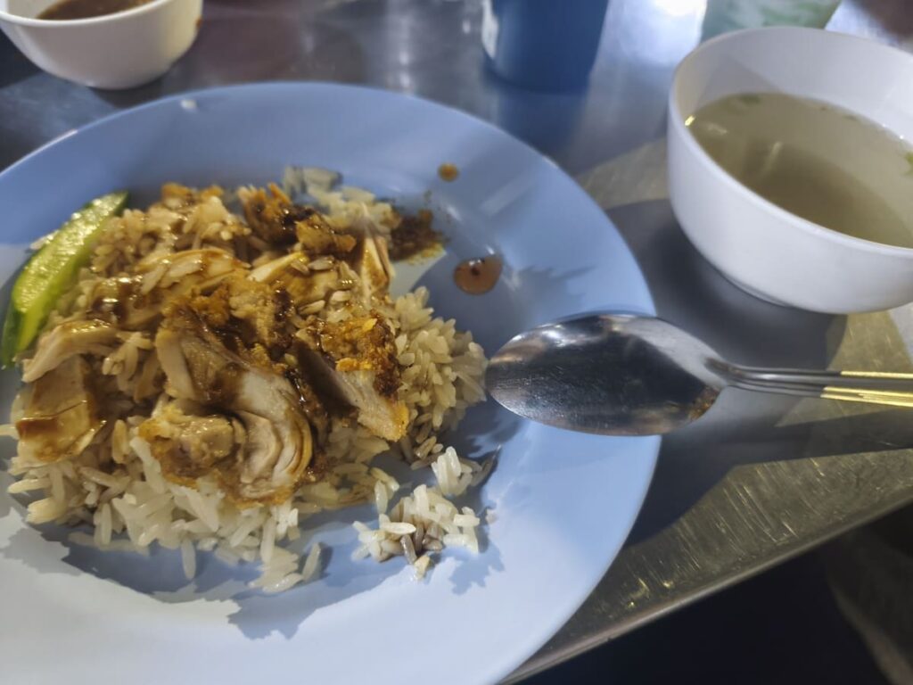 Crispy Pork on rice on a plate and small bowl of soup