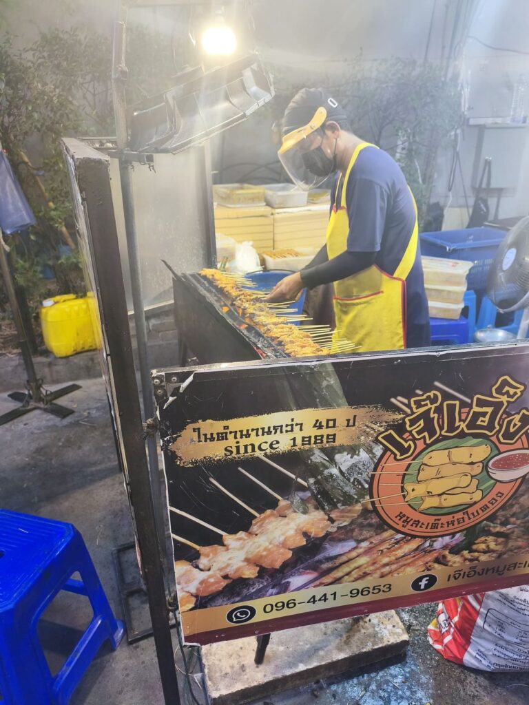 Man grilling meat spits
