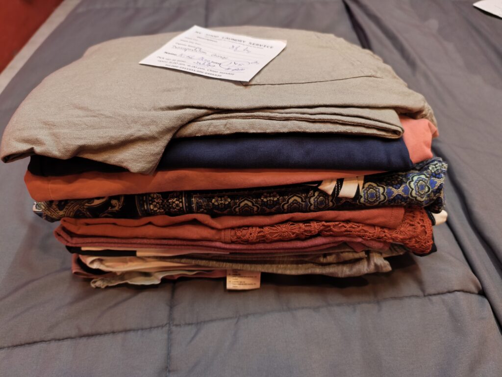 Pile of folded clothing on bed