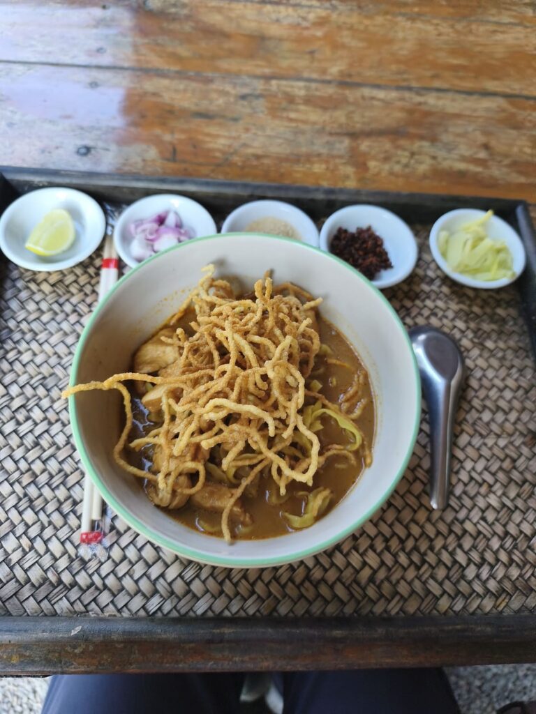 Bowl with khao soi as well as small dishes with condiments