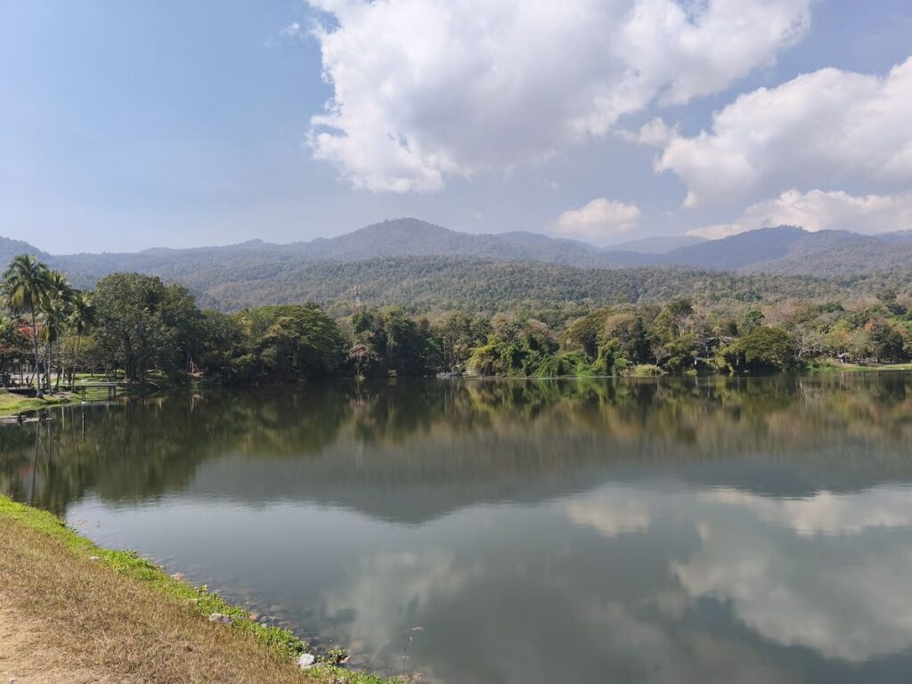 Lake surrounded by trees with hills in background