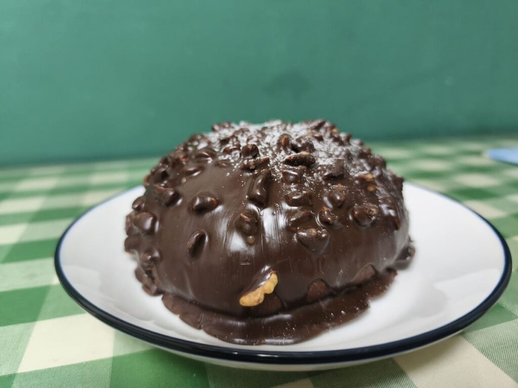 Plate with a chocolate bakery item with nuts on top
