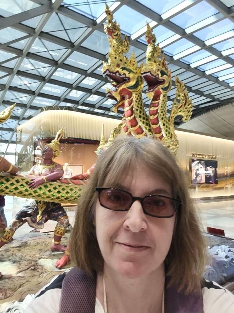 Kitty in front of dragon statue at Bangkok airport