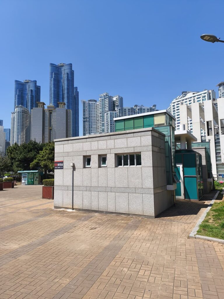Public restroom in Busan with skyscrapers in background