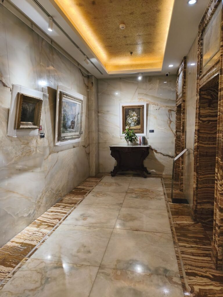 Marble hallway with art at AC Art Museum Hotel