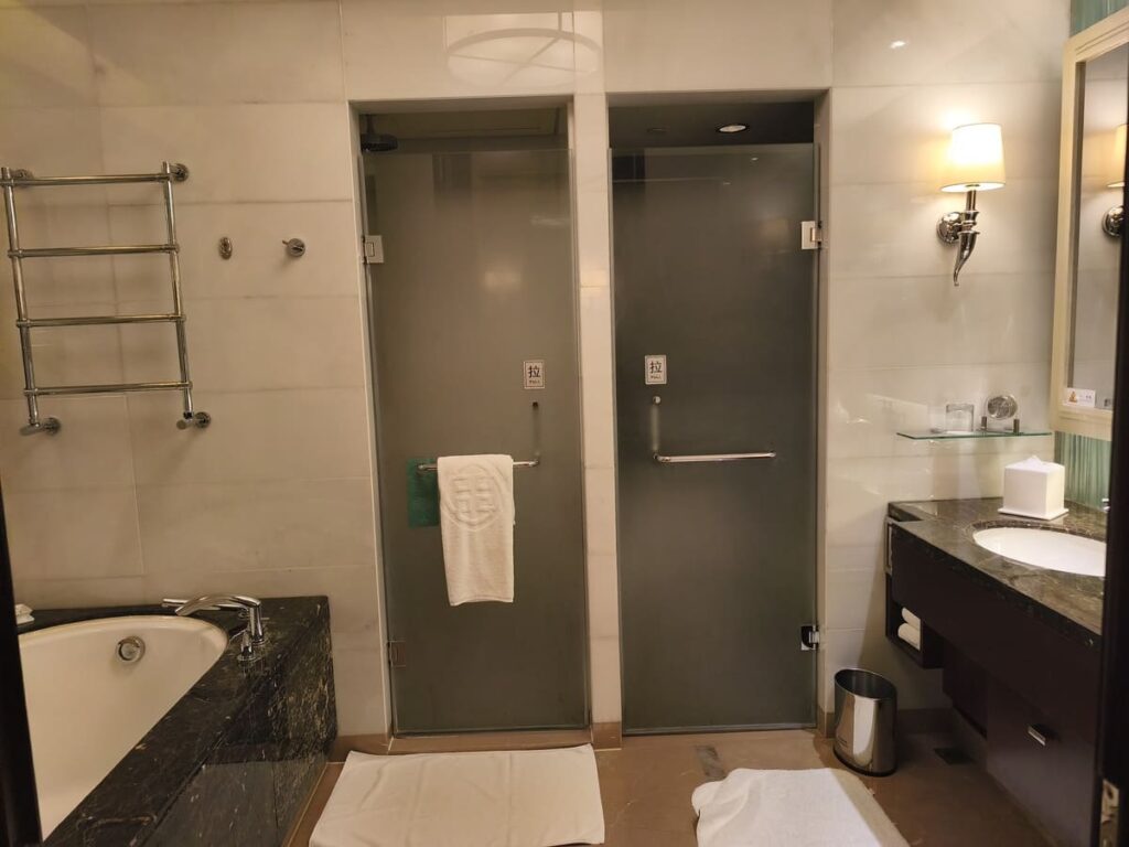 Bathroom with tub, sinks, and doors to shower and toilet